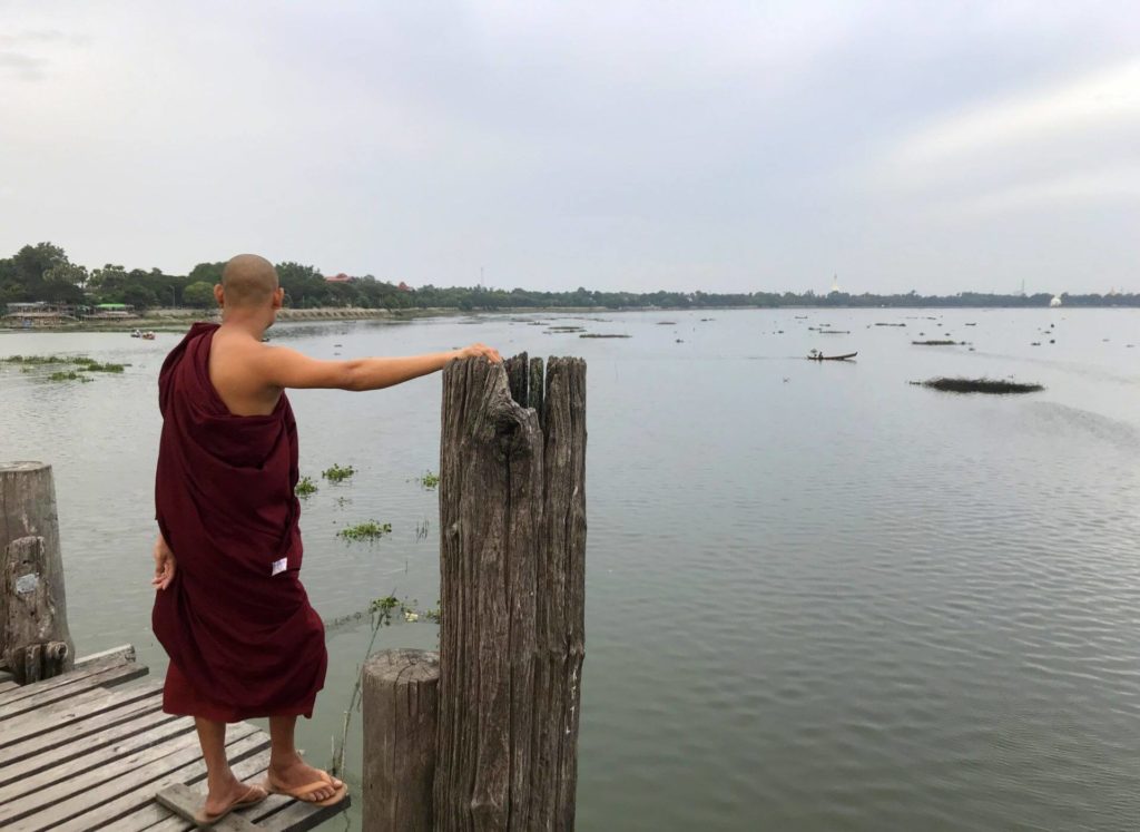 Un monje observa el lago desde el U bein Bridge